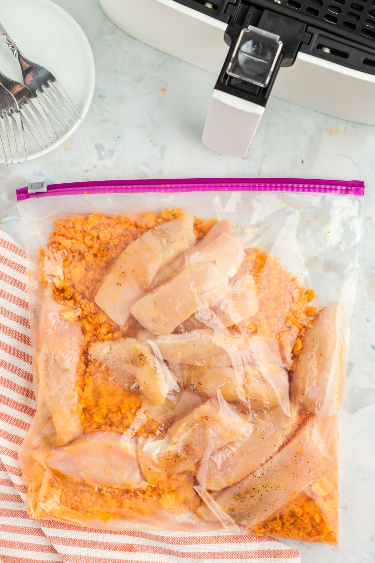 Chicken in a Ziploc bag with crushed dorito chips