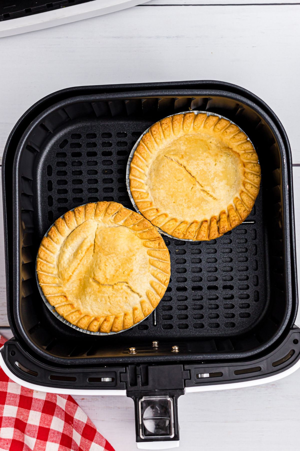 Golden pot pies in the air fryer basket after being cooked