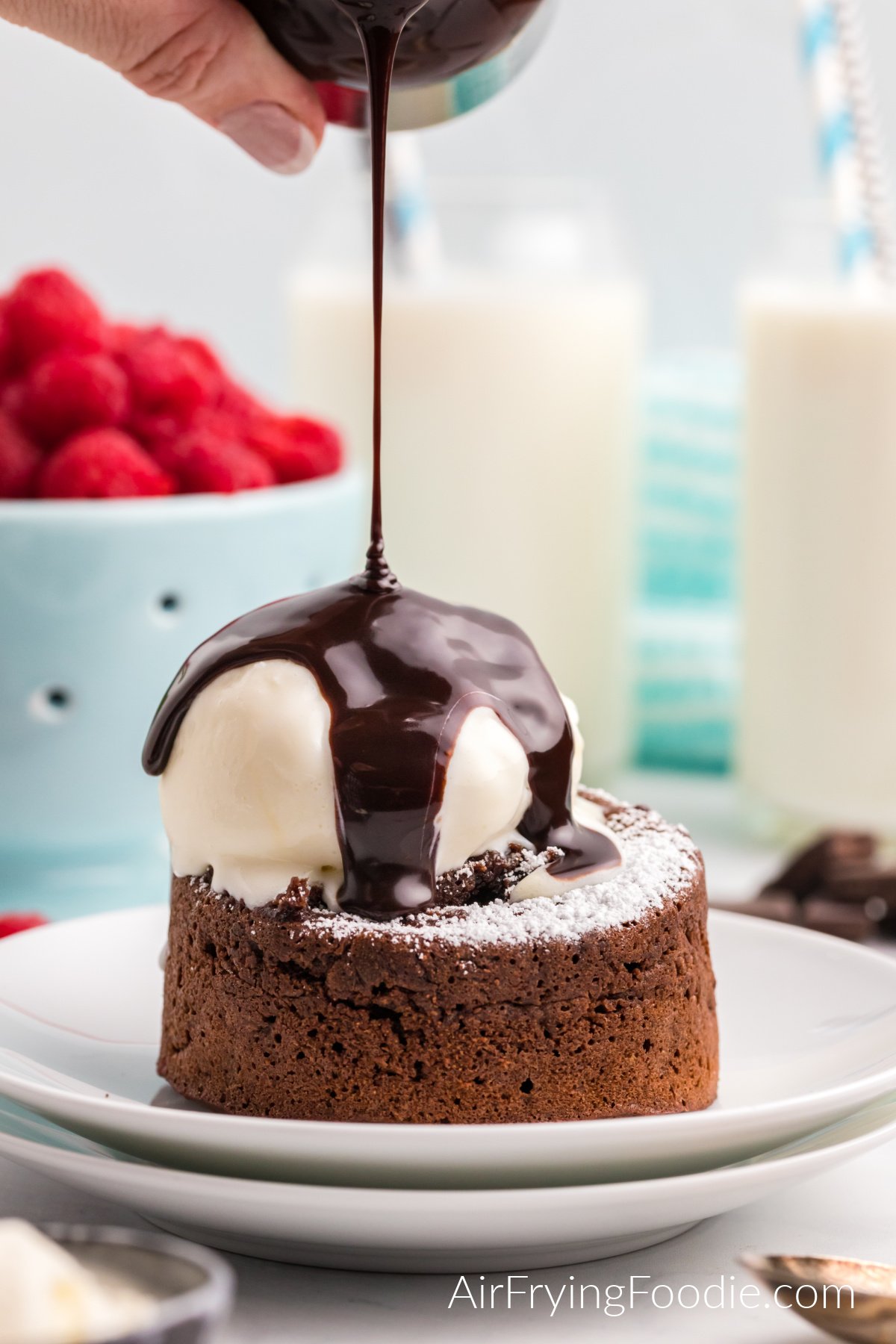 Air Fryer Lava cake topped with confectioner's sugar, ice cream, and chocolate sauce.