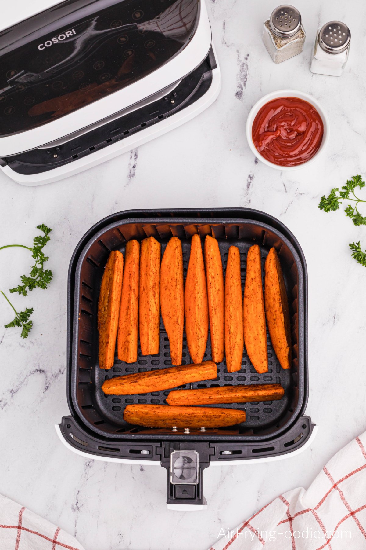 Sweet potato wedges in air fryer basket ready to cook.