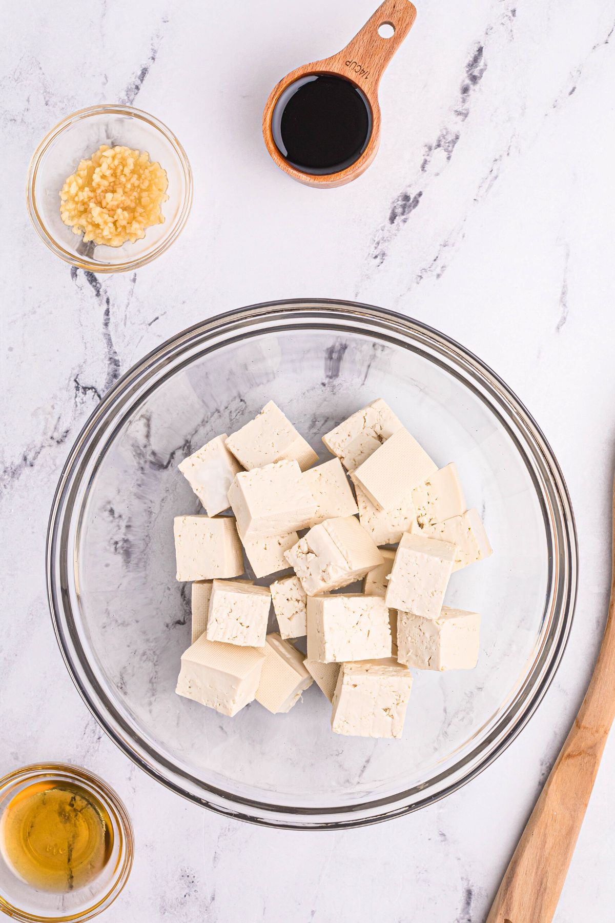 Tofu cut into cubes in a clear glass bowl