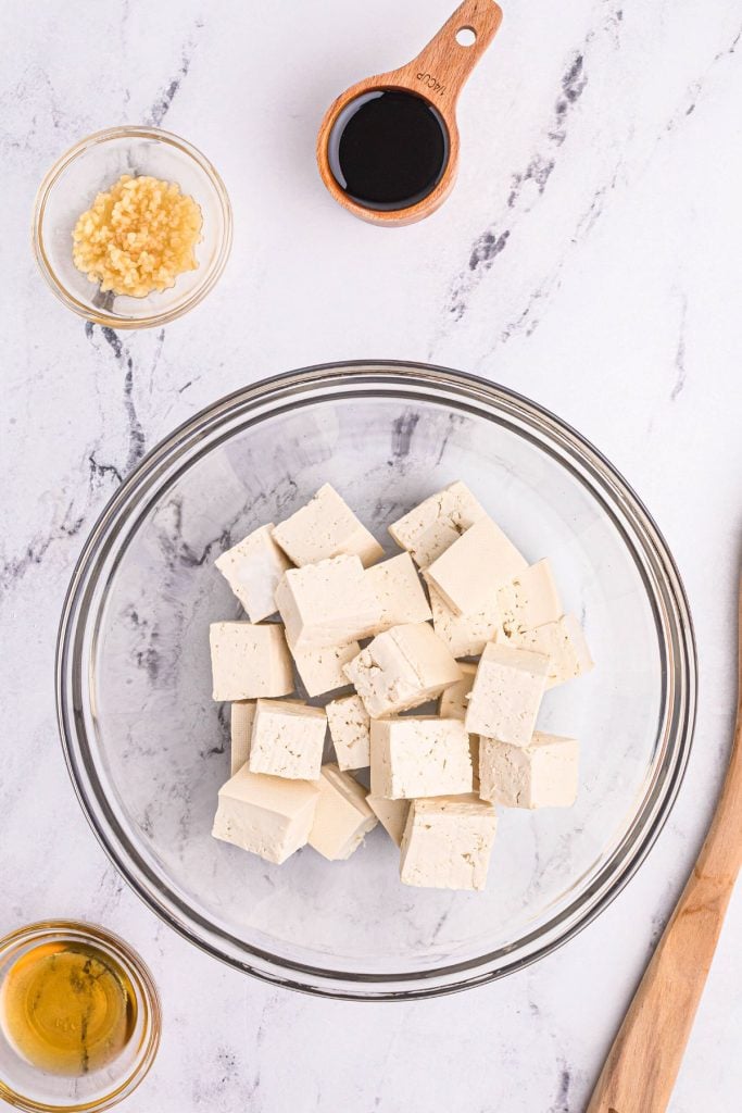 Ingredients needed to make tofu on a white marble board.
