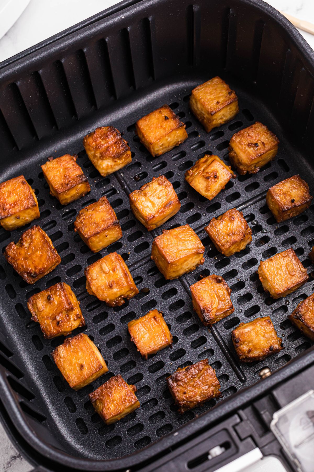 Golden crispy tofu in the air fryer basket. 