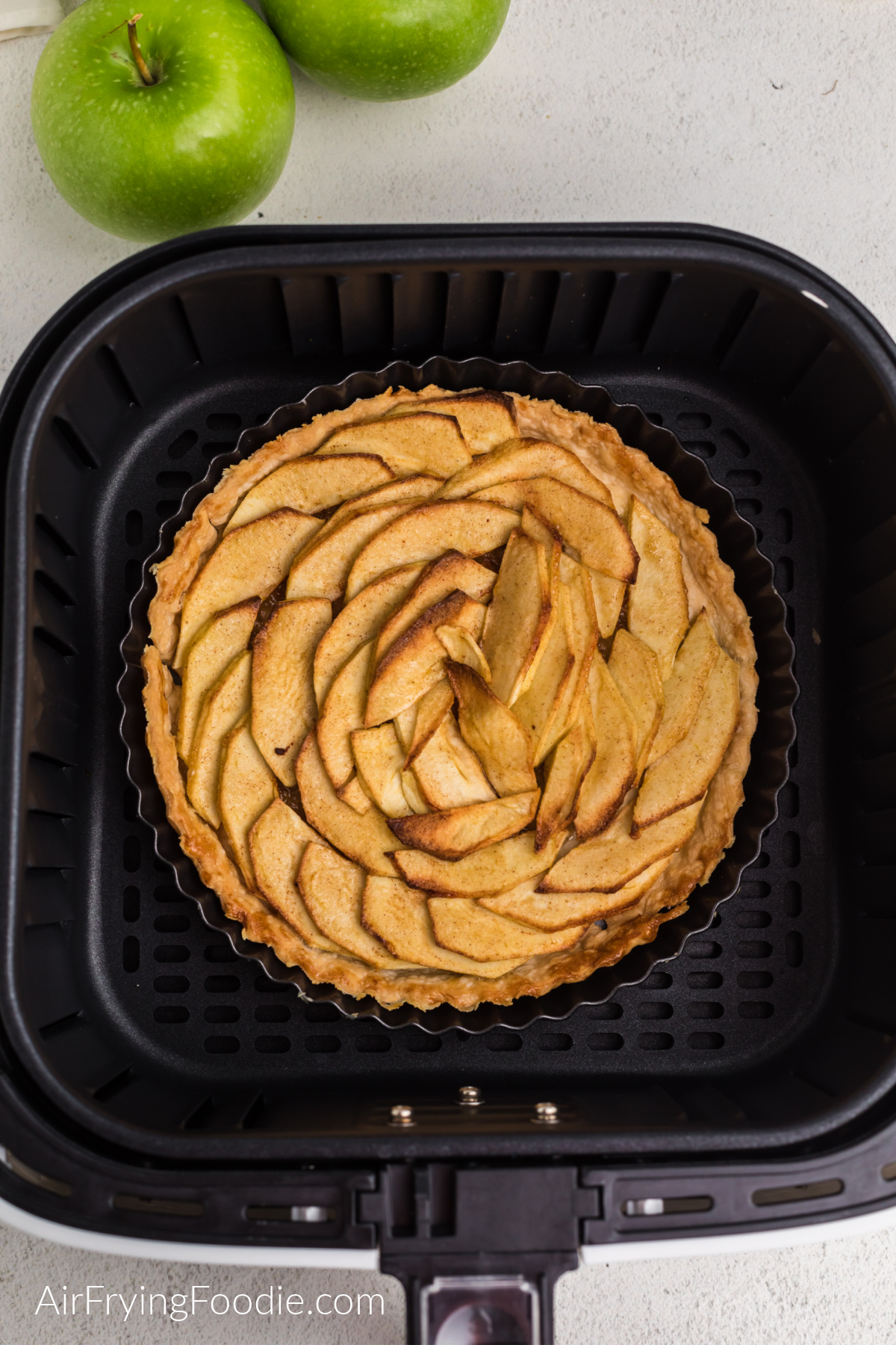 Cooked apple tart in the basket of the air fryer.