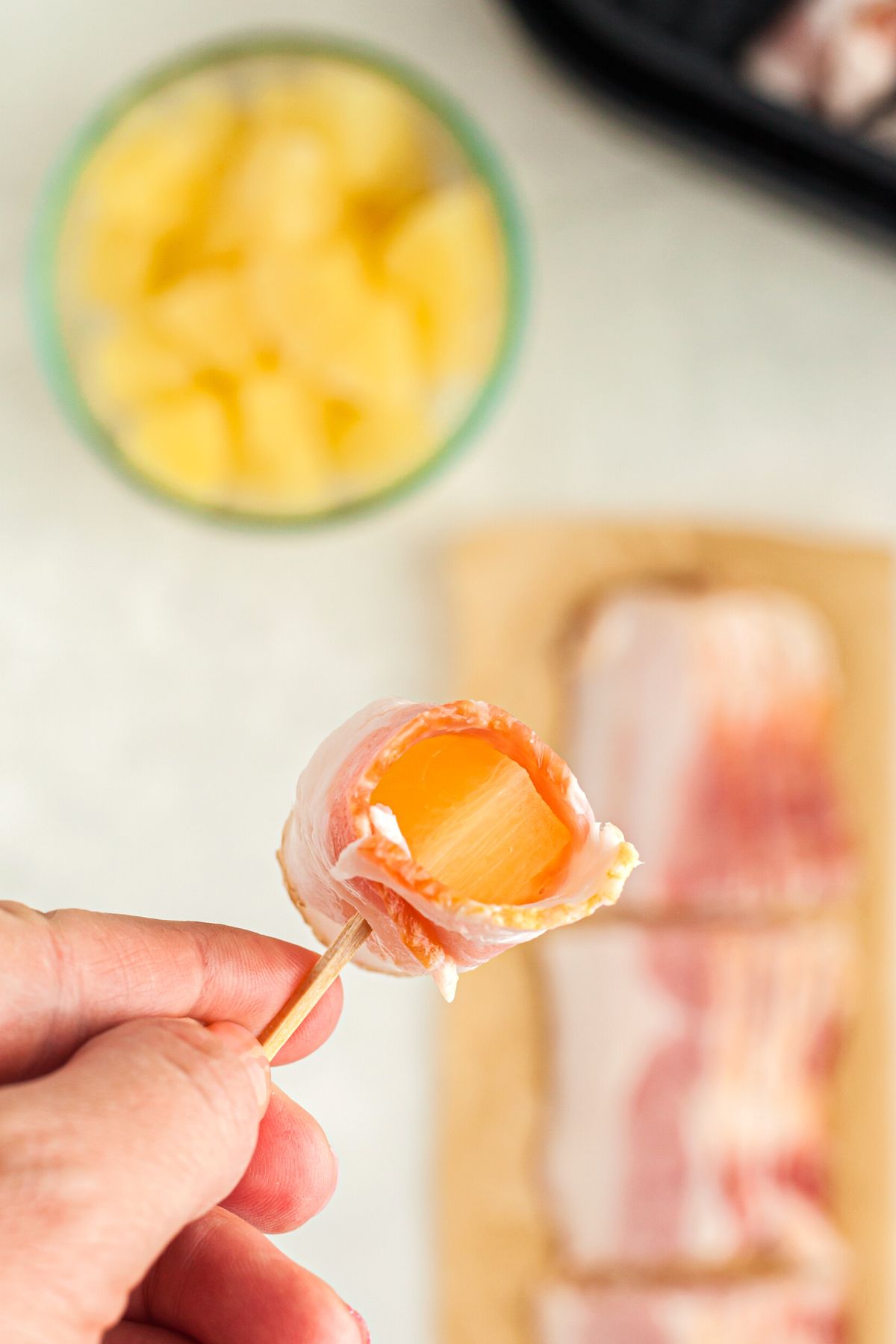 One chunk of pineapple wrapped in a third slice of bacon, then secured with a toothpick