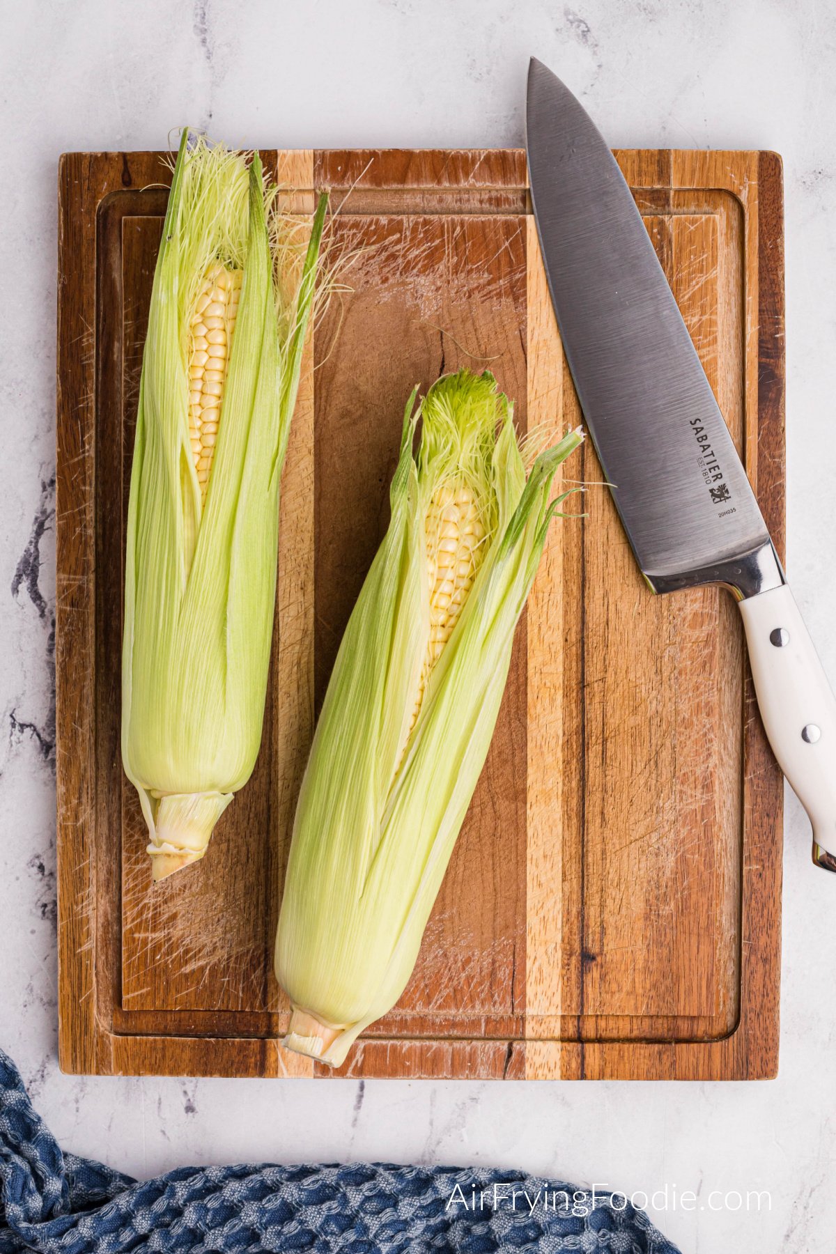 Corn on a cutting board.