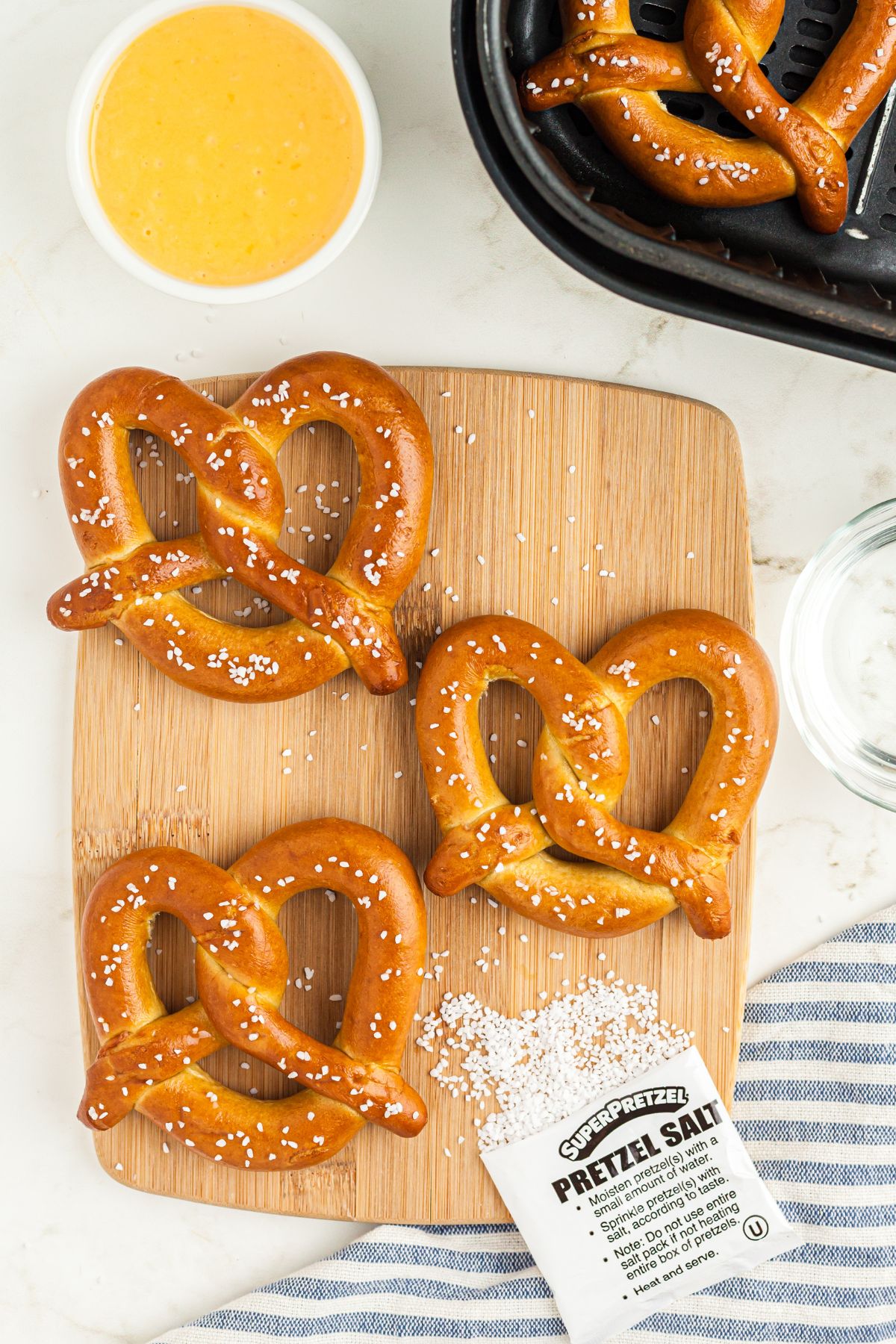 Golden frozen pretzels on a board sprinkled with salt before air frying