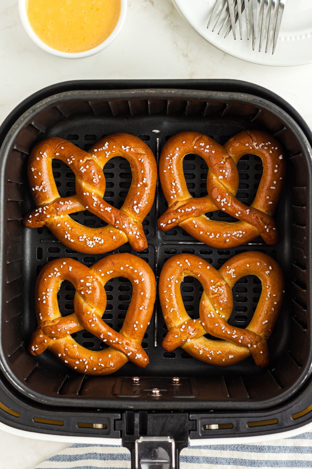 Frozen pretzels in the air fryer basket before being reheated
