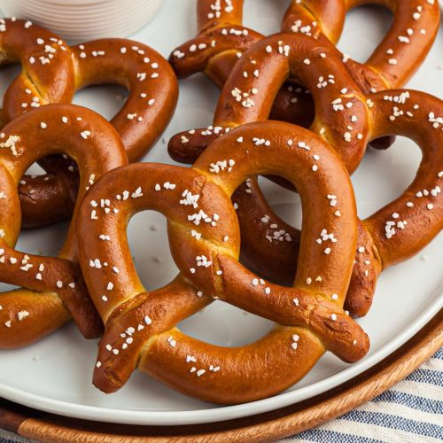 Golden salted covered pretzels on a white plate