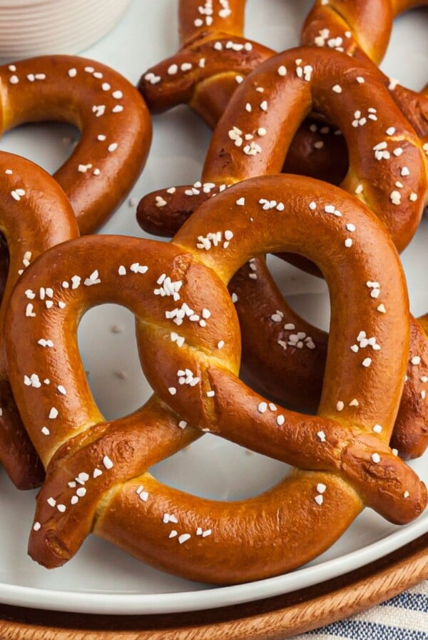 Golden salted covered pretzels on a white plate