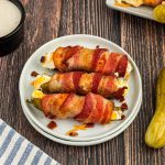 Bacon wrapped pickle poppers on a small white plate