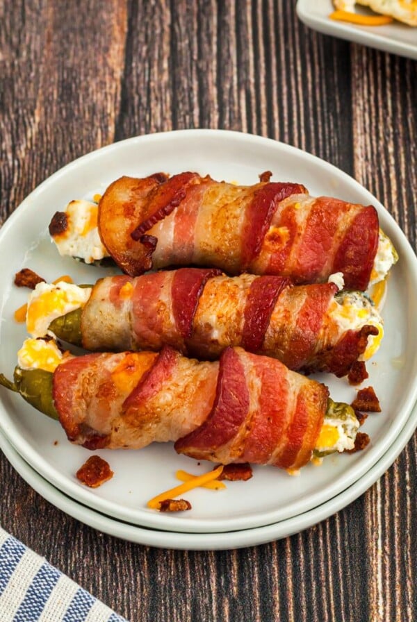 Bacon wrapped pickle poppers on a small white plate