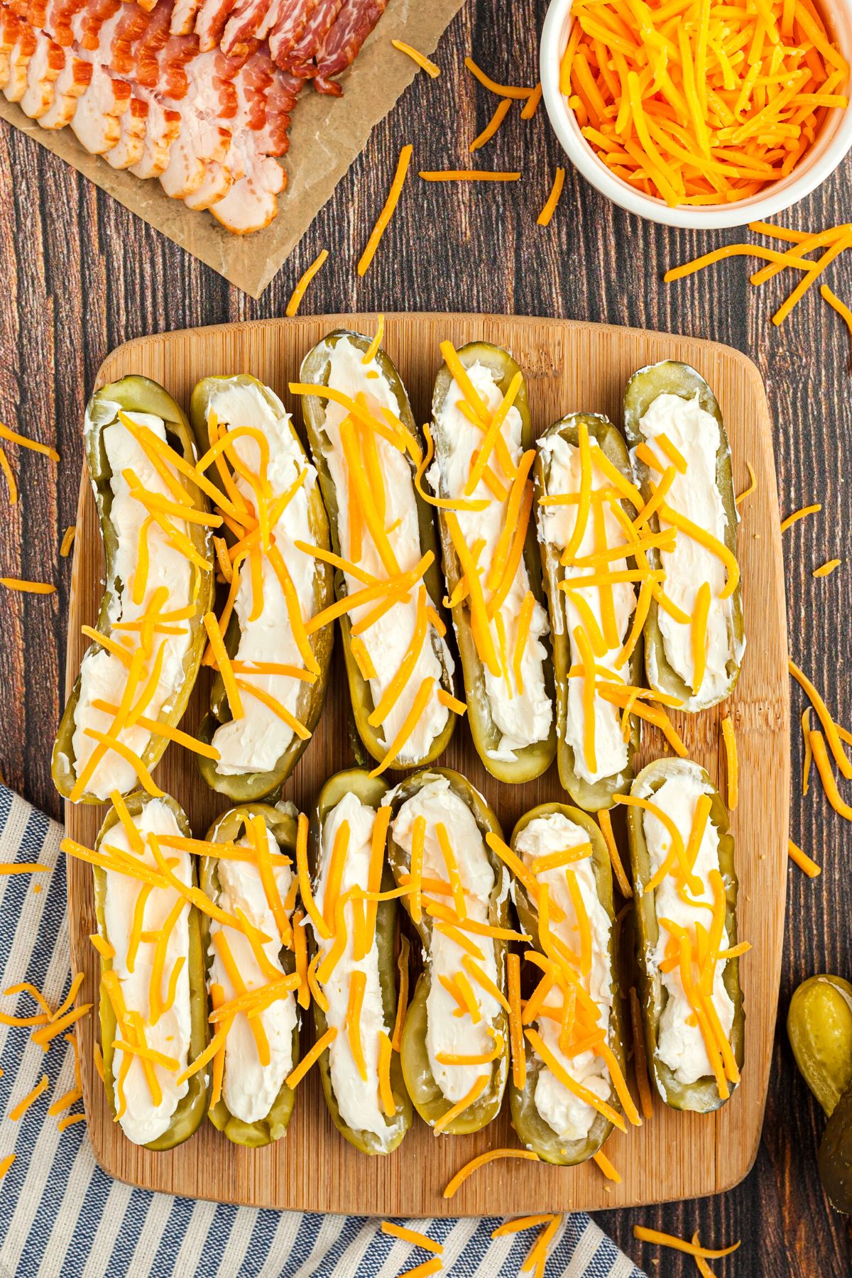 Pickles sliced in half and filled with cream cheese and shredded cheddar cheese
