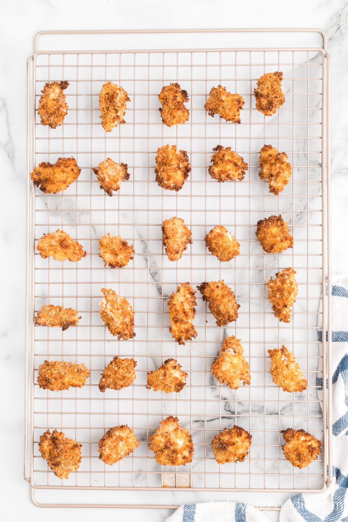 Air fried popcorn chicken on a wired cooling rack to stay crispy before serving.