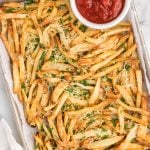 Overhead shot of truffle fries on a serving platter with a side of ketchup in a bowl.