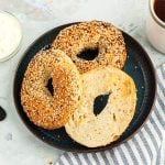 Lightly golden toasted bagels on a blue plate served with cream cheese