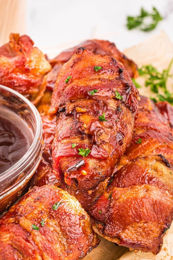 Armadillo eggs coated with bbq sauce and stacked on a plate