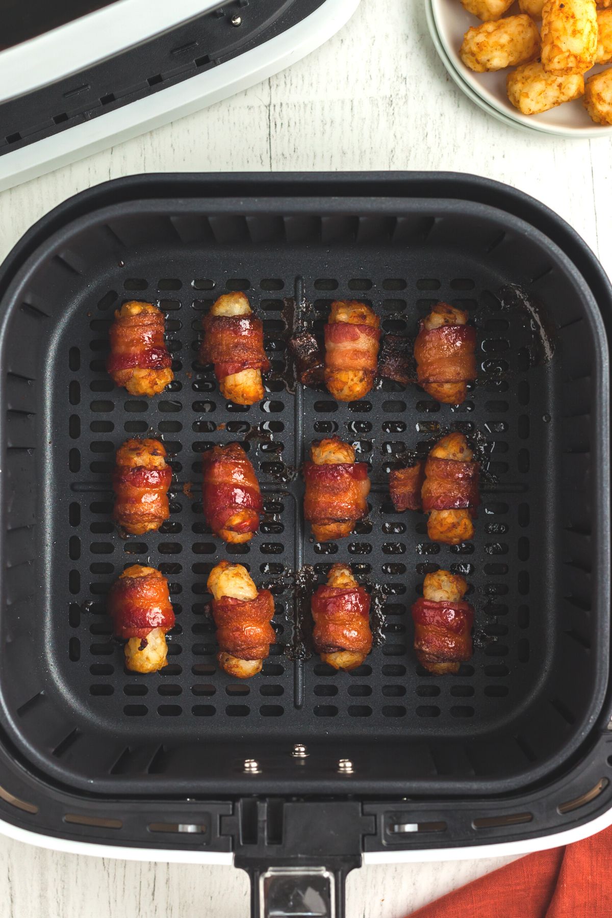 Crispy bacon wrapped tater tots in the air fryer basket