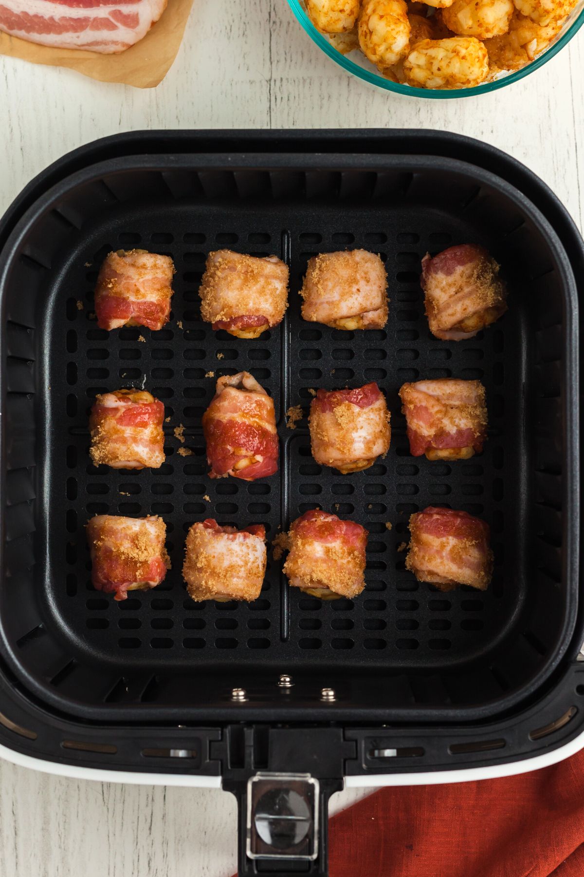 Bacon wrapped and sugar coated tater tots in the air fryer basket