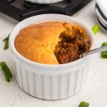 Chili pot pie with a bite missing.