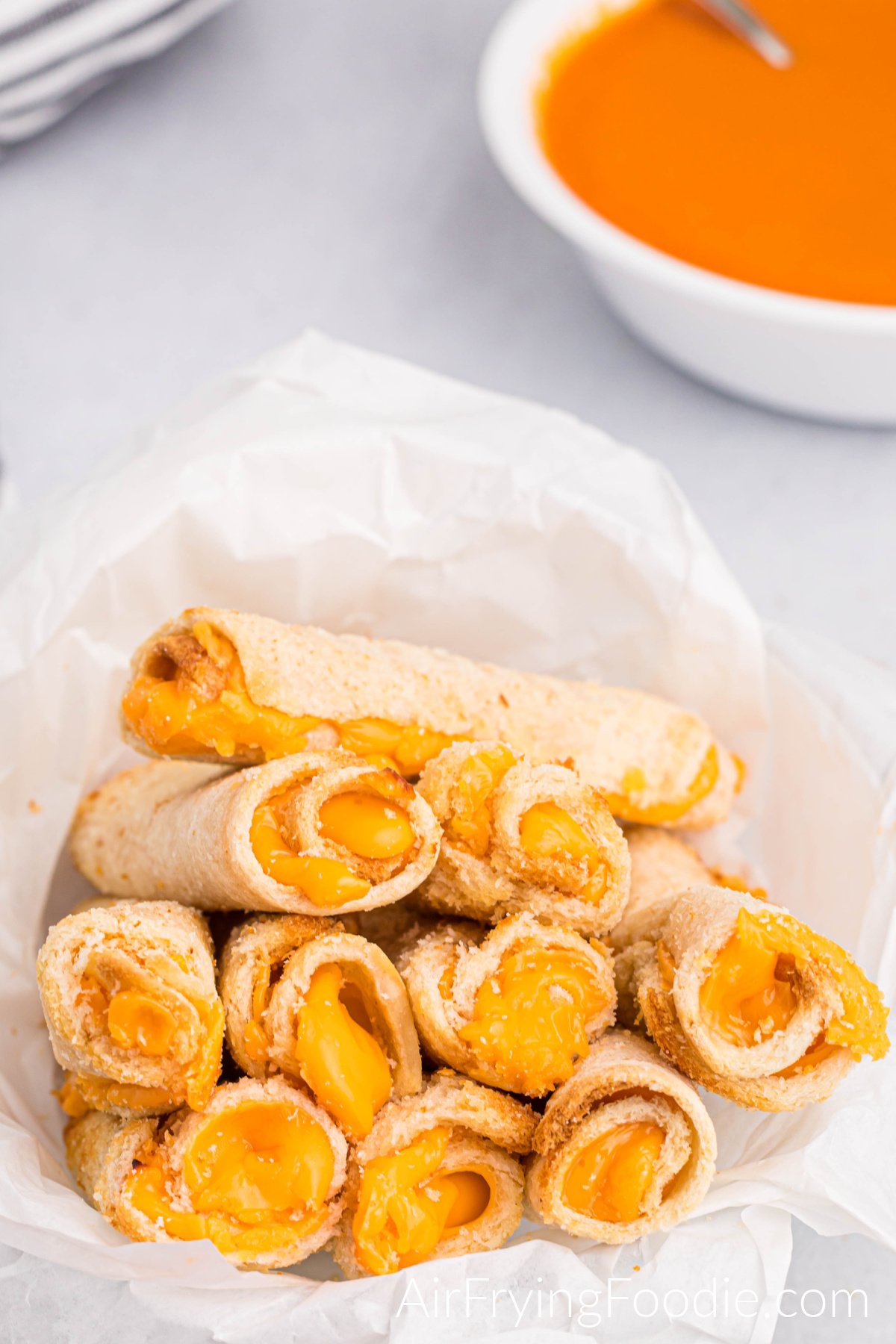 Grilled cheese roll ups cooked in the air fryer and ready to serve with a side of tomato soup.