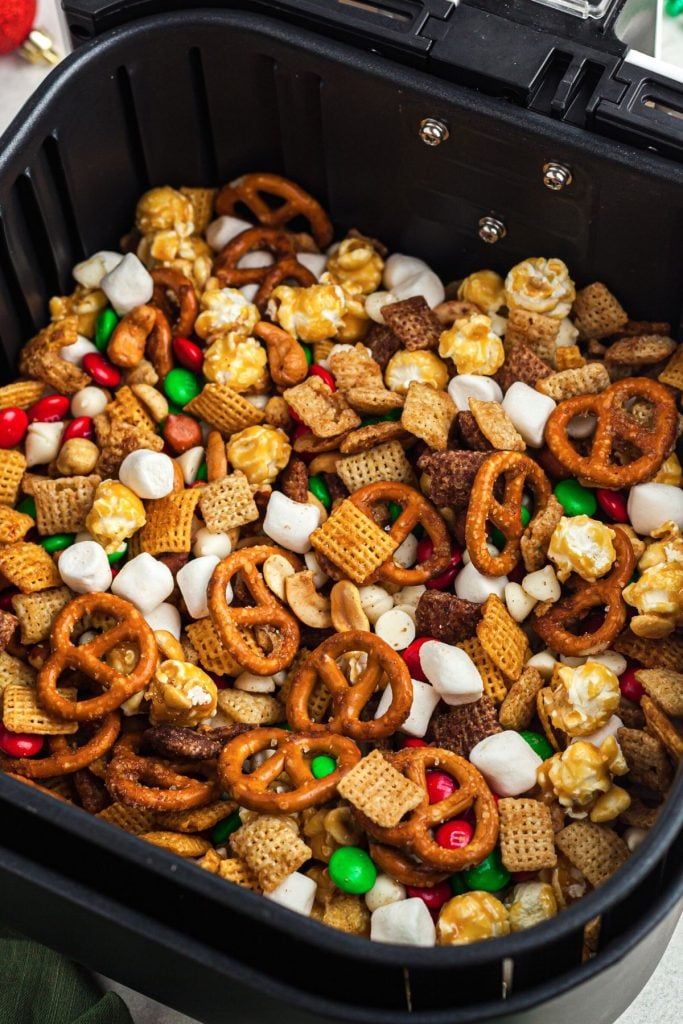 Candies, marshmallows, and cereals mixed together in an air fryer basket