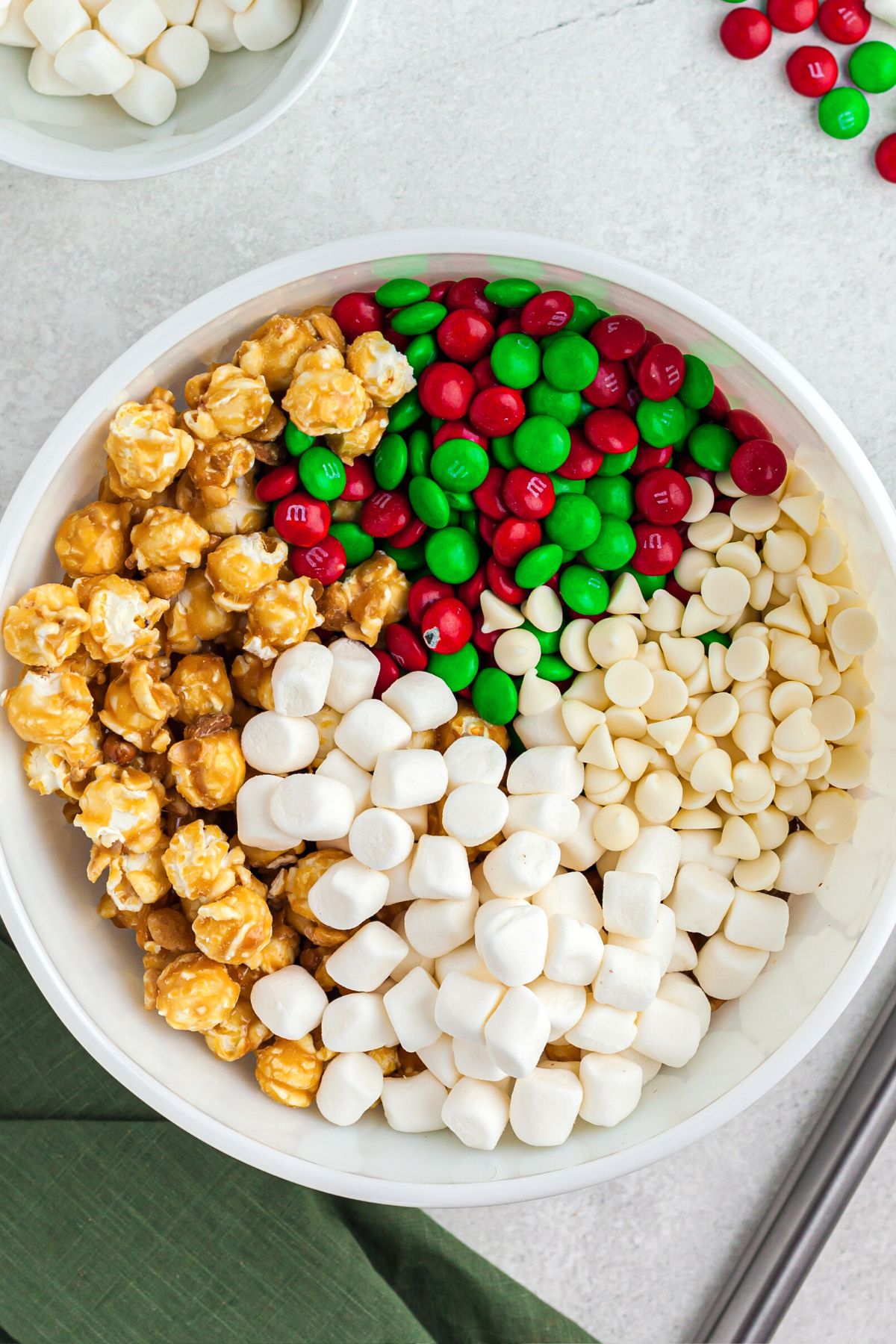 Marshmallows, popcorn and candies mixed in a white bowl