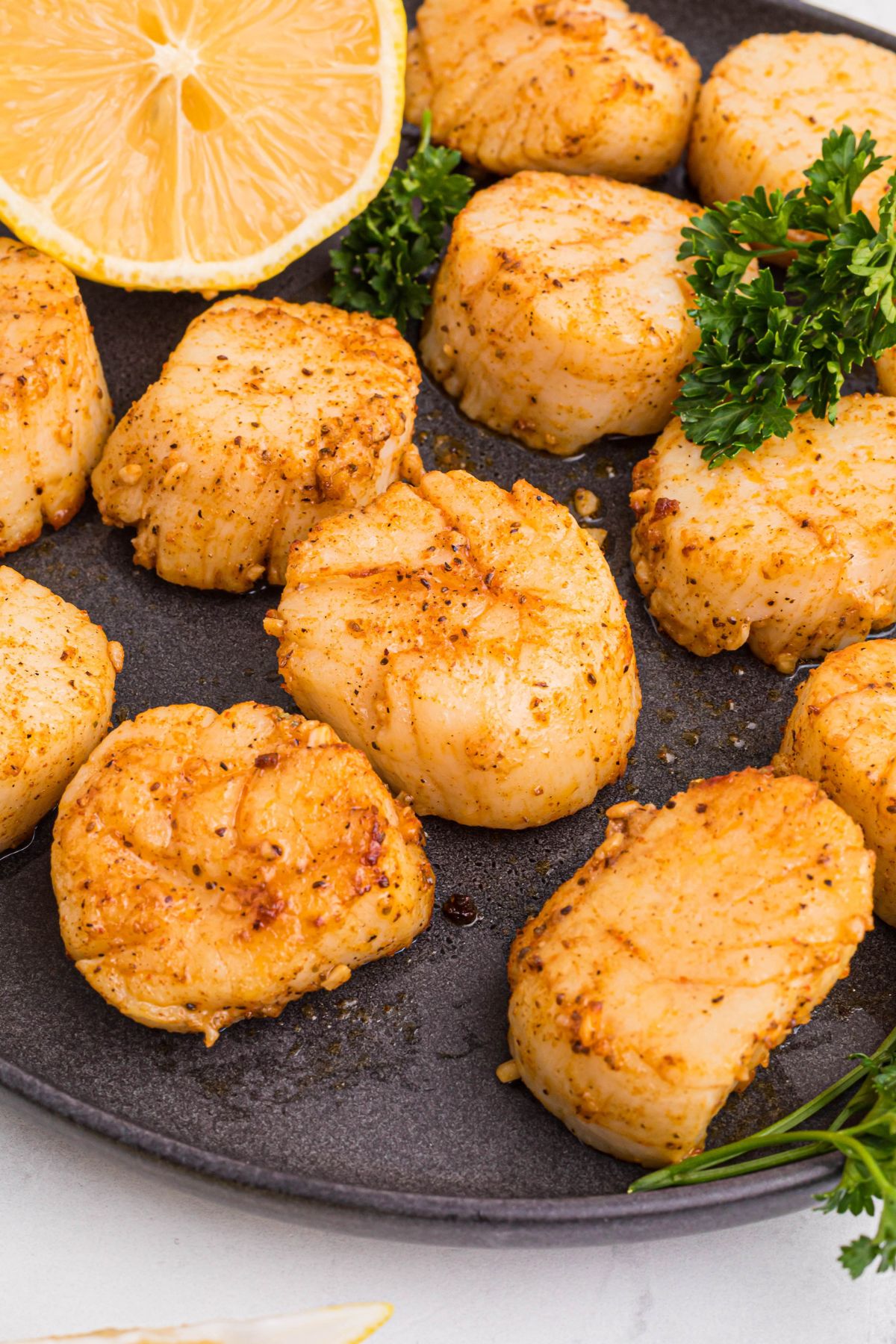 air fried scallops on a black plate. 