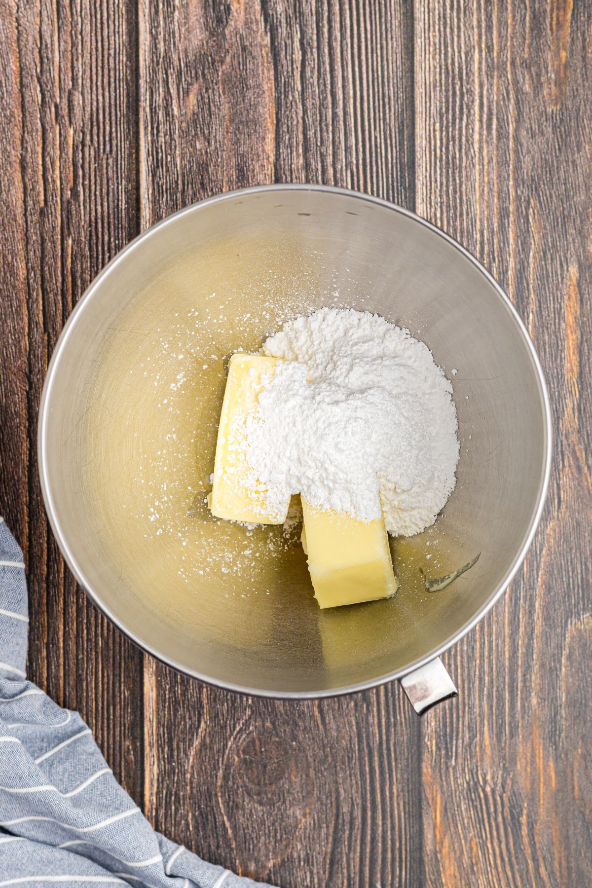 Butter and powdered sugar being mixed together in a bowl