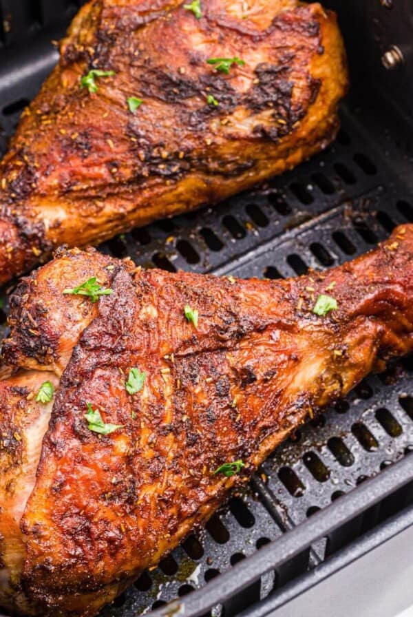 Golden brown crispy turkey legs in the air fryer basket.