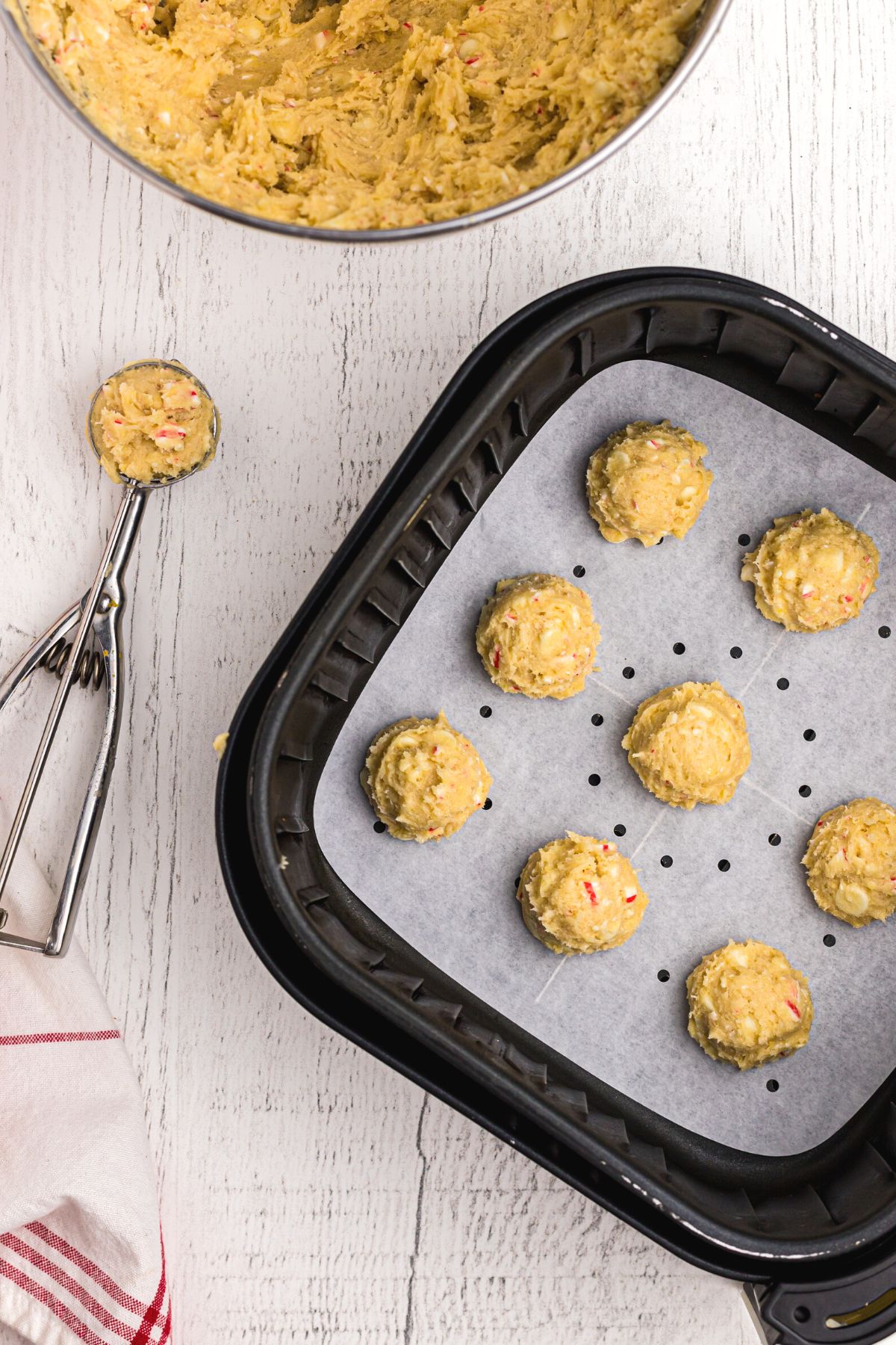Cookie dough being scooped into air fryer basket