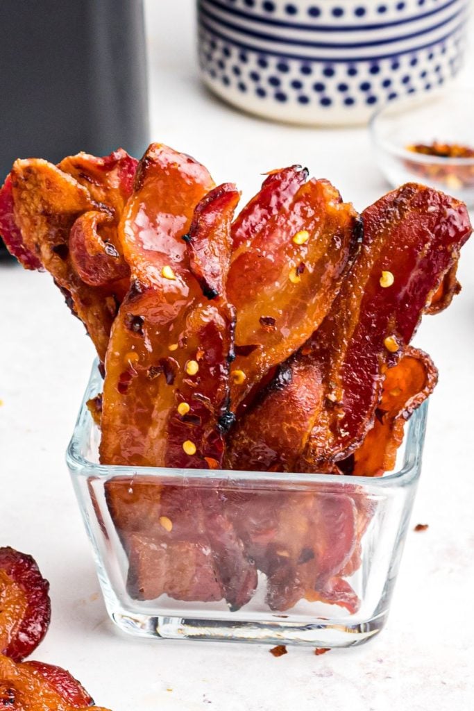Juicy bacon in a glass jar seasoned with red pepper flakes.