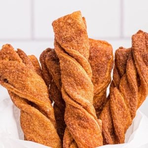 Golden sugar and cinnamon coated twists stacked in parchment paper