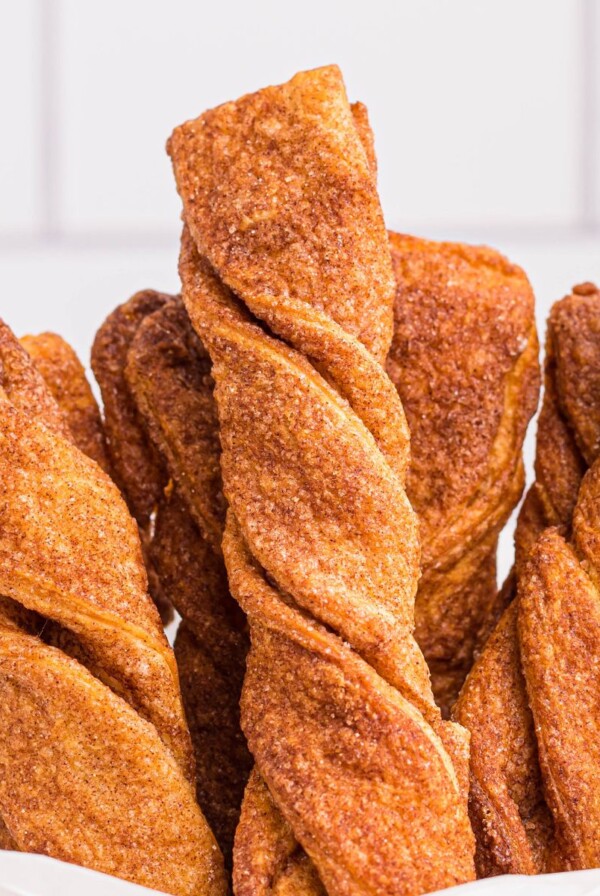 Golden sugar and cinnamon coated twists stacked in parchment paper