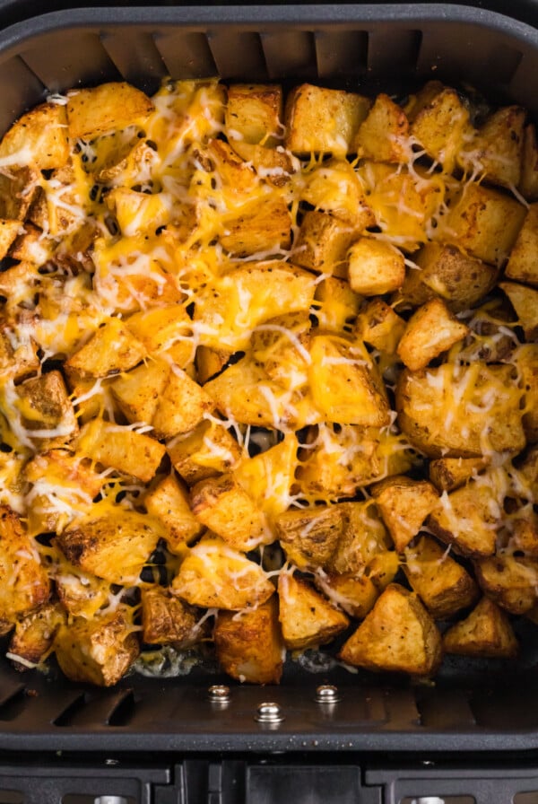 Cheesy potatoes in the basket of the air fryer.