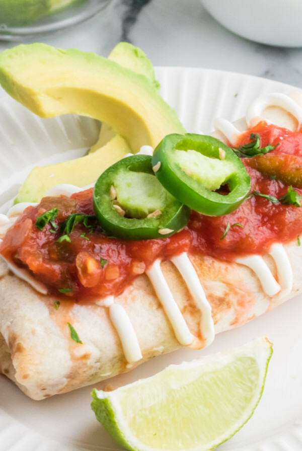 Air Fryer Chimichanga on a plate with toppings, ready to serve.