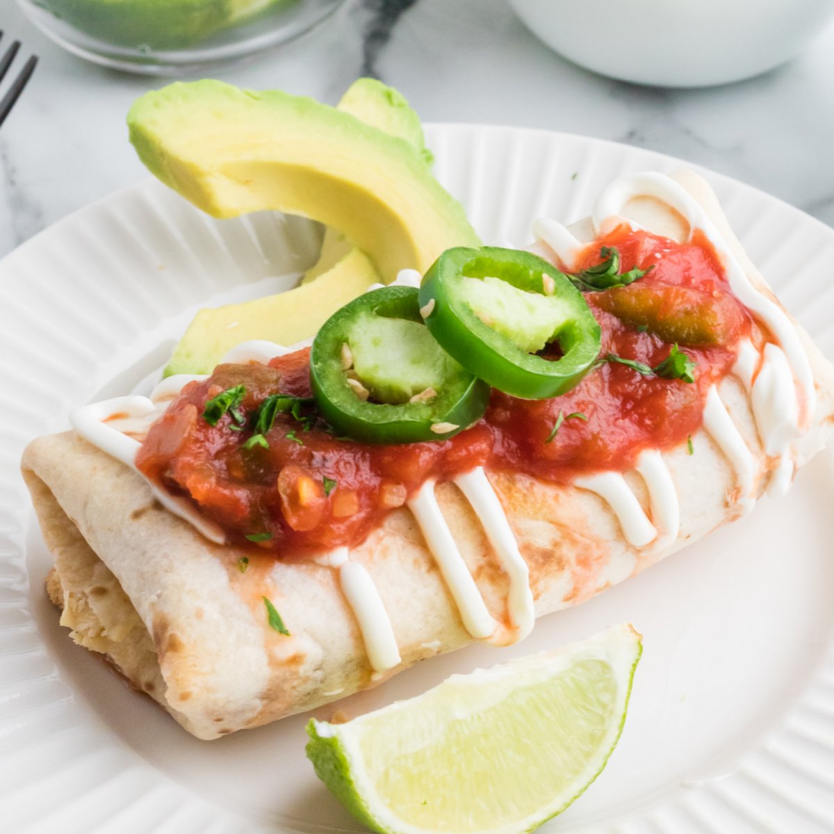 Air Fryer Chimichanga on a plate with toppings, ready to serve.