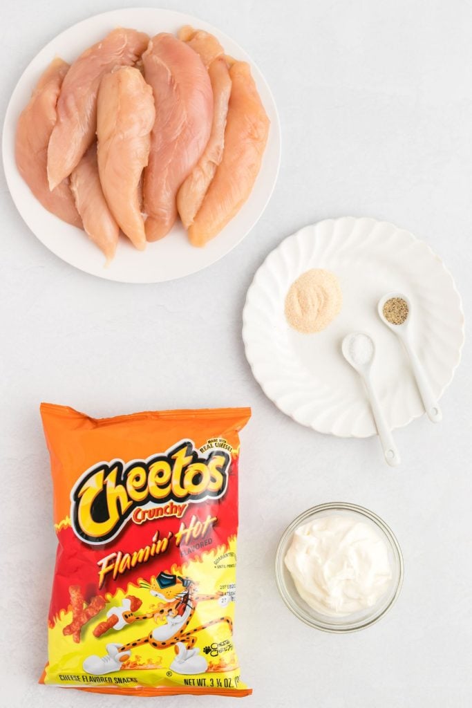 Ingredients needed to make flamin hot cheeto chicken  on a white marble table 