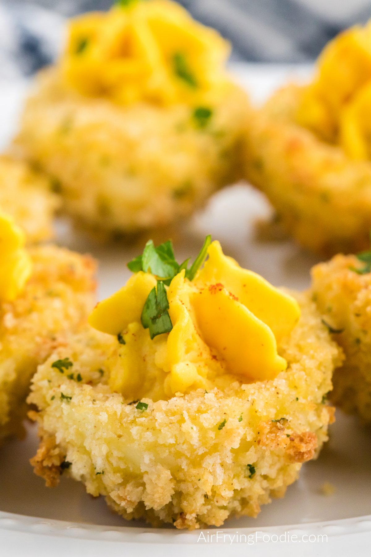 Air fryer fried deviled eggs on a white plate ready to serve.