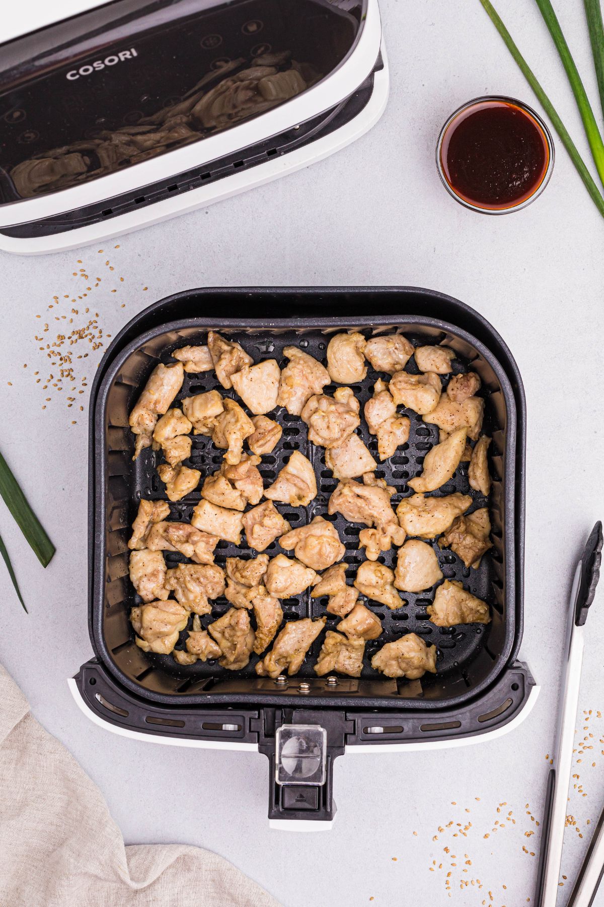 golden cooked pieces of chicken in the air fryer basket