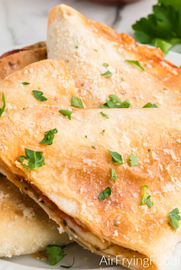 Pizza quesadilla made in the air fryer and topped with parmesan cheese and parsley.