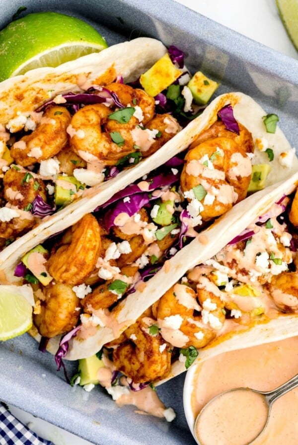 Shrimp tacos stuffed and stacked in a gray baking pan