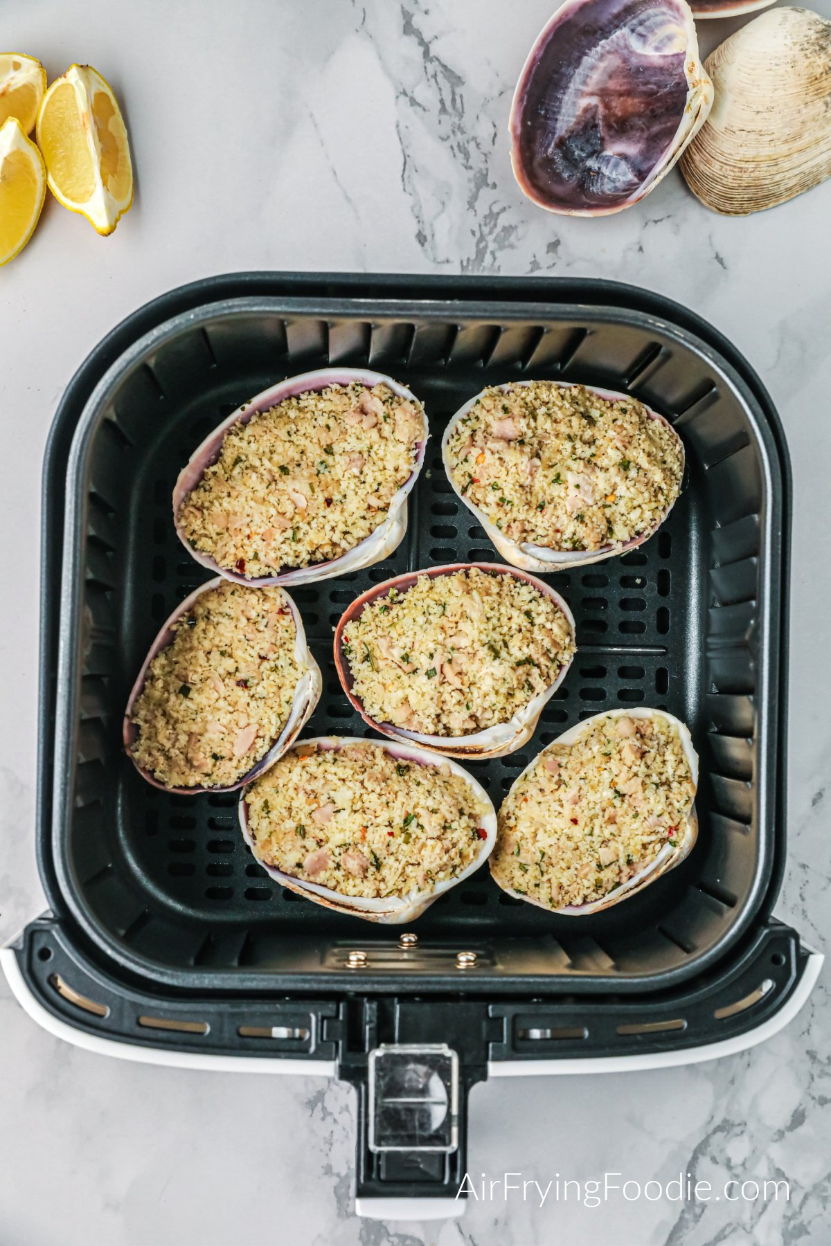 Stuffed clams in a single layer of the air fryer basket.
