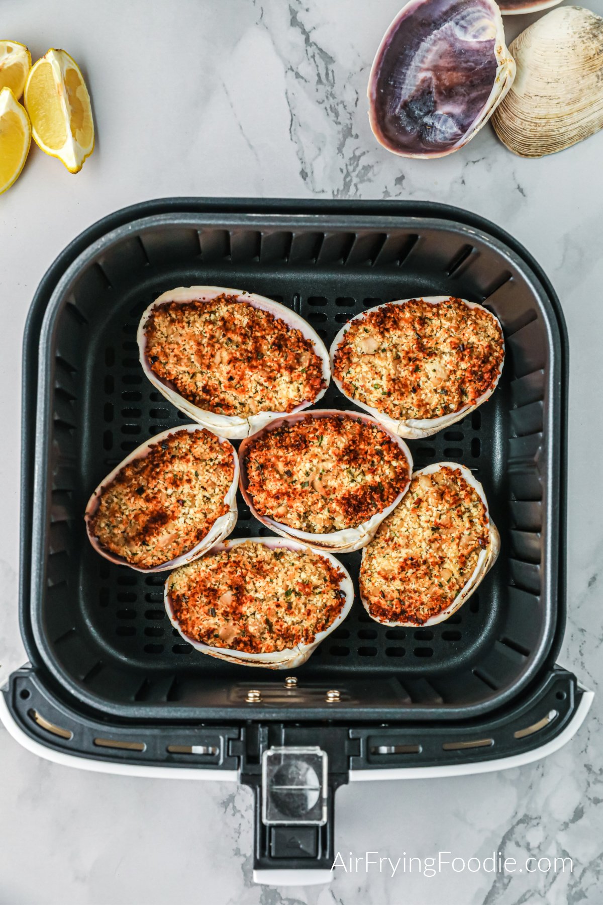 Golden brown stuffed clams in the basket of the air fryer.
