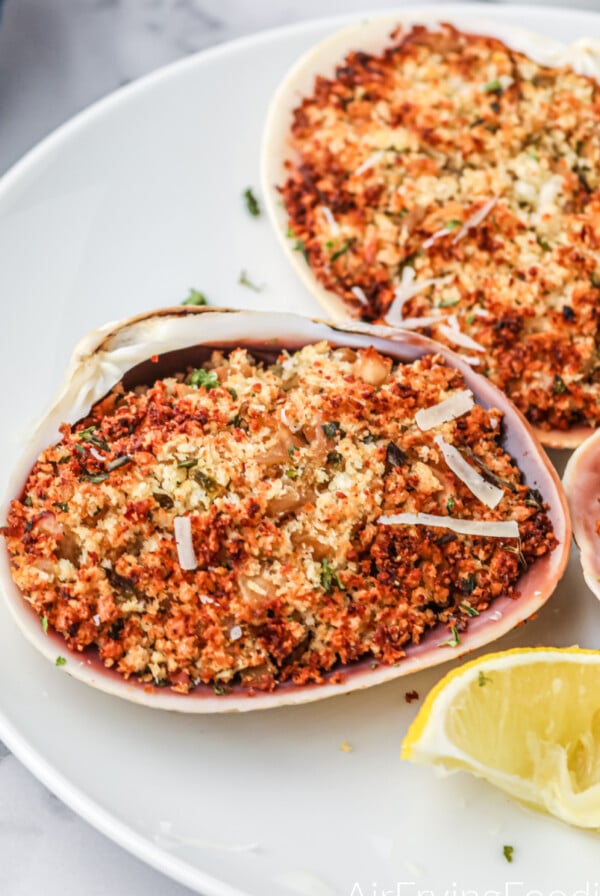 Closeup overhead shot of stuffed clams on a white plate.