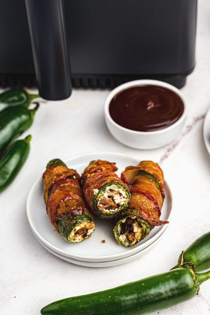 Golden crispy bacon wrapped around jalapenos stuffed with cream cheese and bacon
