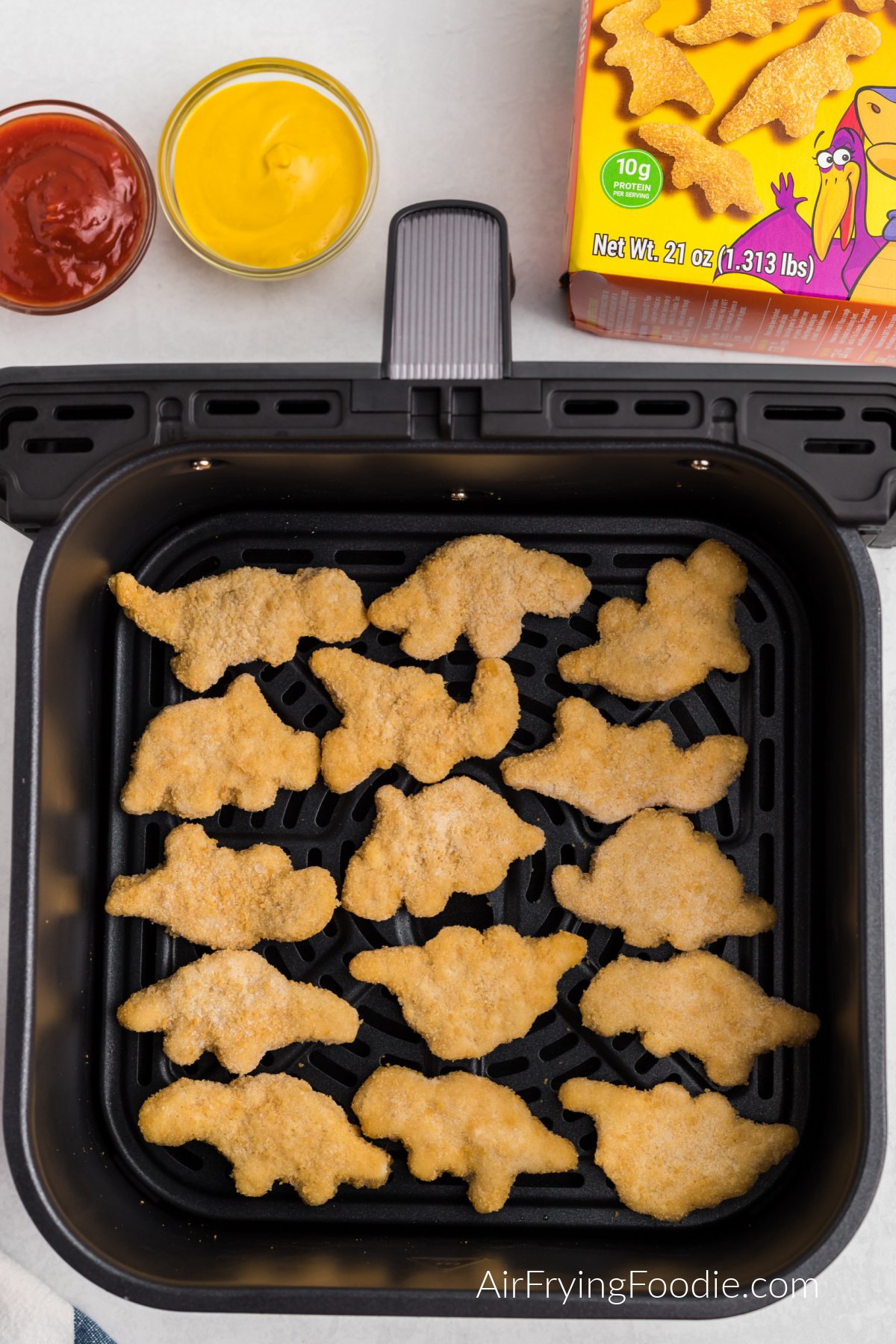 Dino nuggets in the air fryer basket. Ready to cook.