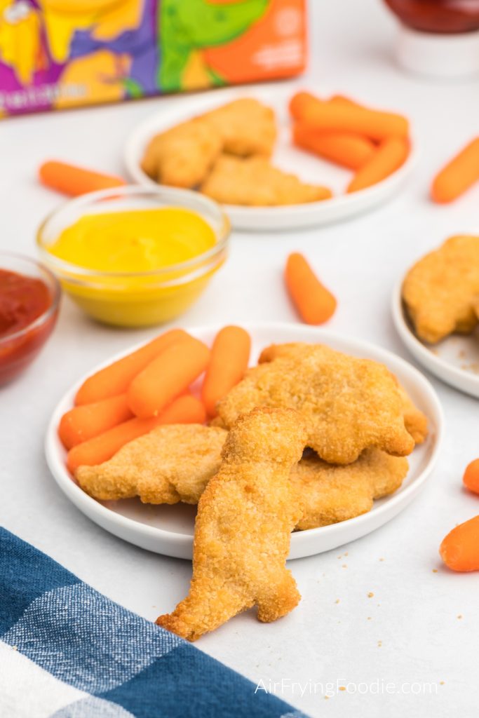 Dino nuggets served with vegetables and dipping sauces.