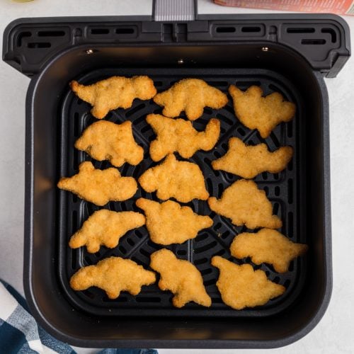 Dino nuggets in air fryer basket, ready to serve.