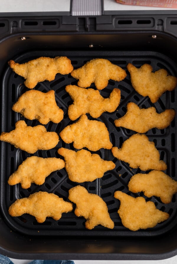 Dino nuggets in air fryer basket, ready to serve.